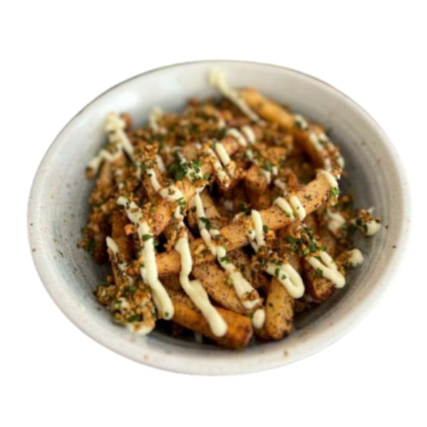 A bowl of golden fries topped with white sauce, green herbs, and brown seasoning.